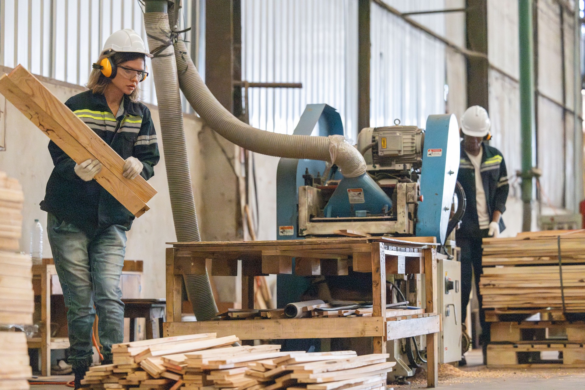 Woodworkers operate machines, tend lathes to cut, shape wood fixtures in manufacturing process